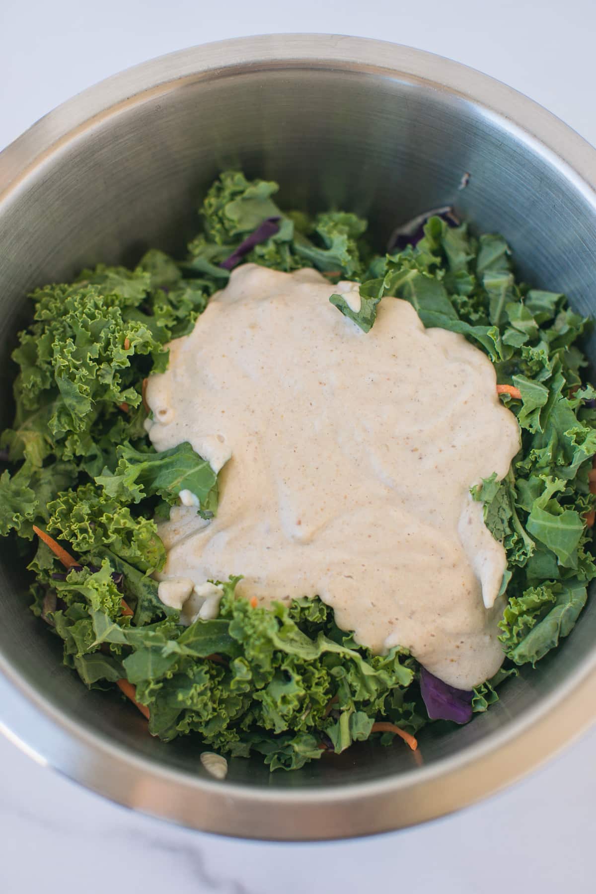 kale salad with dressing on top.