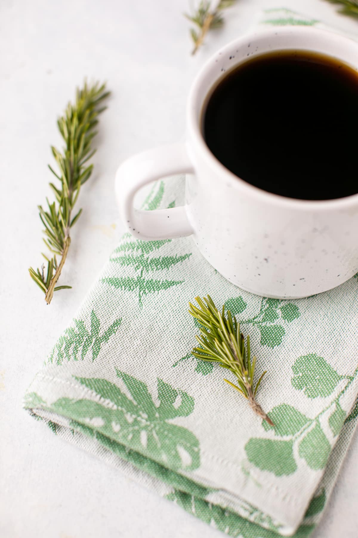 cup of coffee with fresh rosemary sprigs