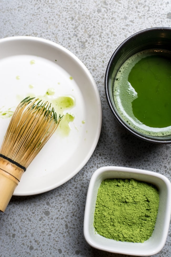 Matcha ingredients on a table with Matcha whisk