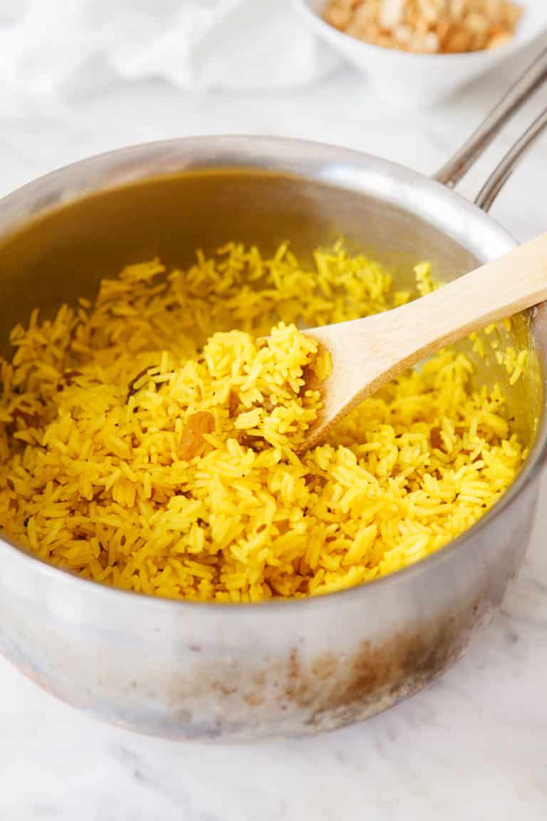 Fluff the yellow rice in the saucepan. 