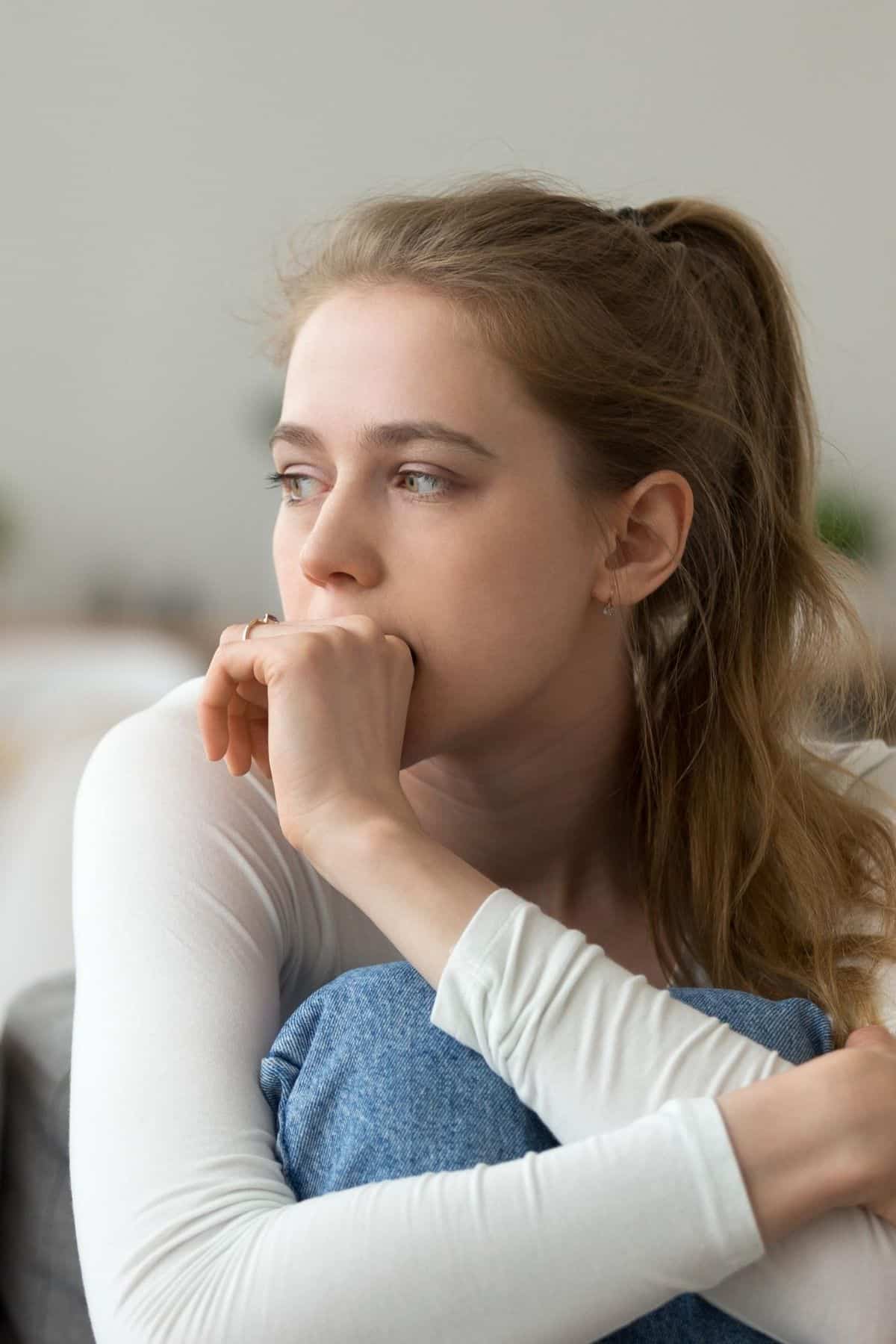 woman sitting on a chair with a worried look on her face.