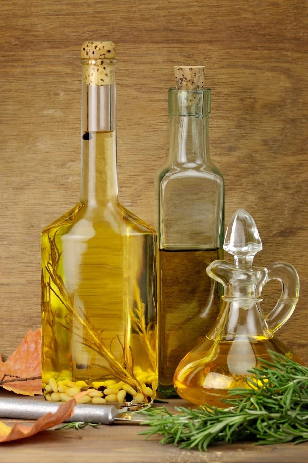 three jars of cooking oil in varying sizes and colors