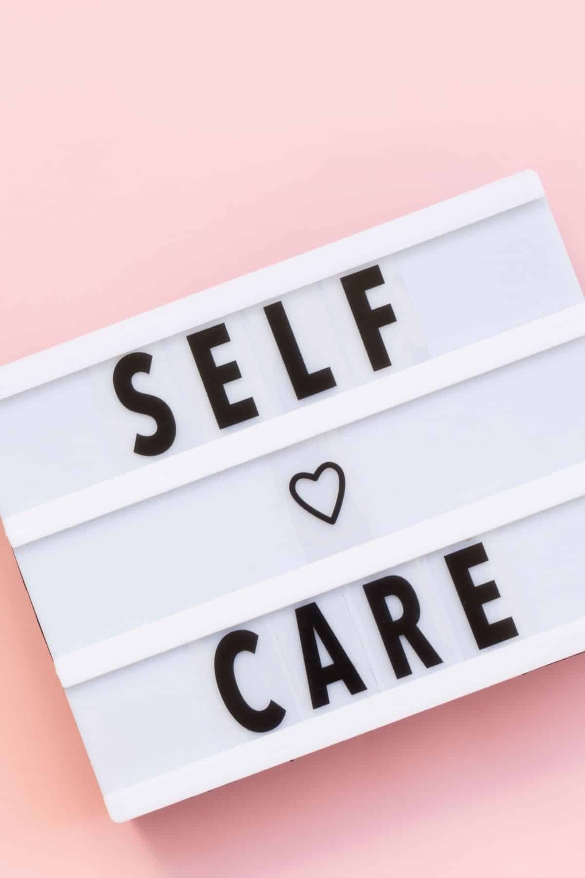 sign with self care in black letters