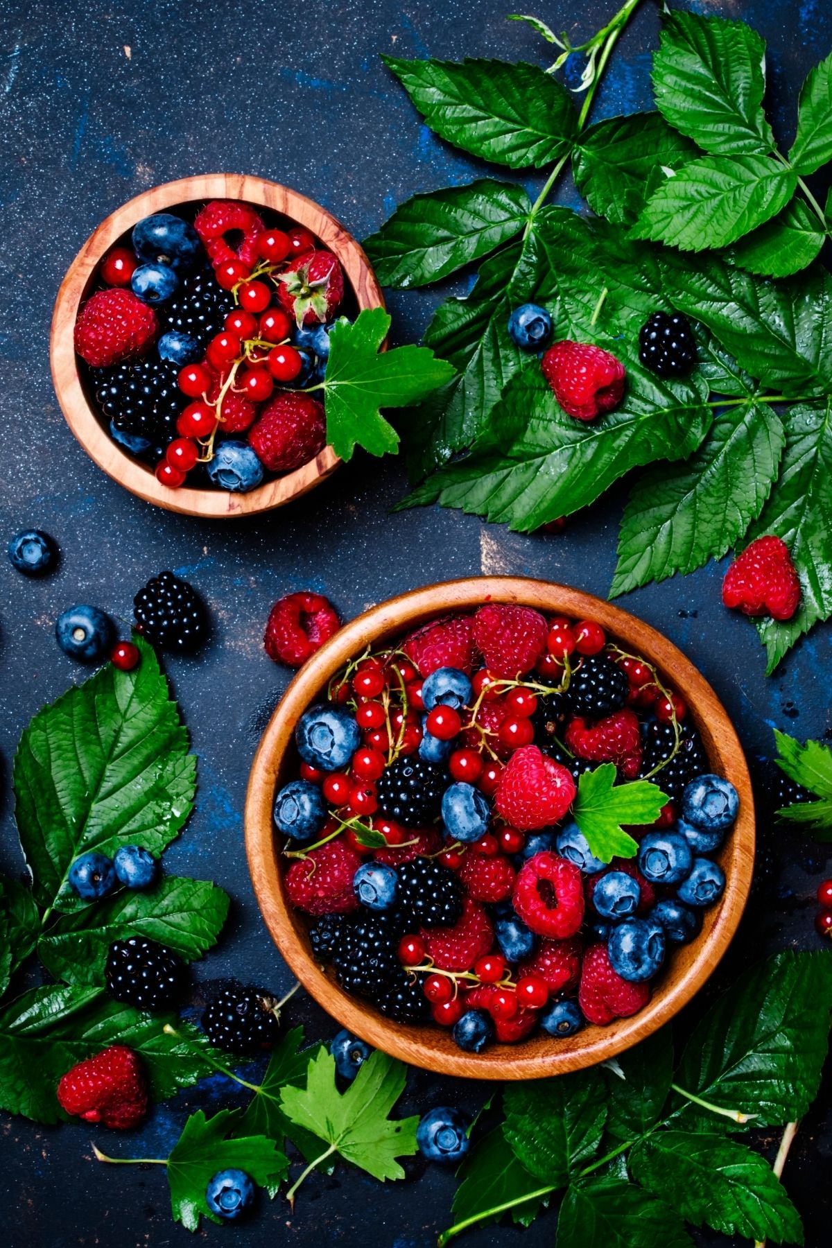 two bowls of berries on a table.