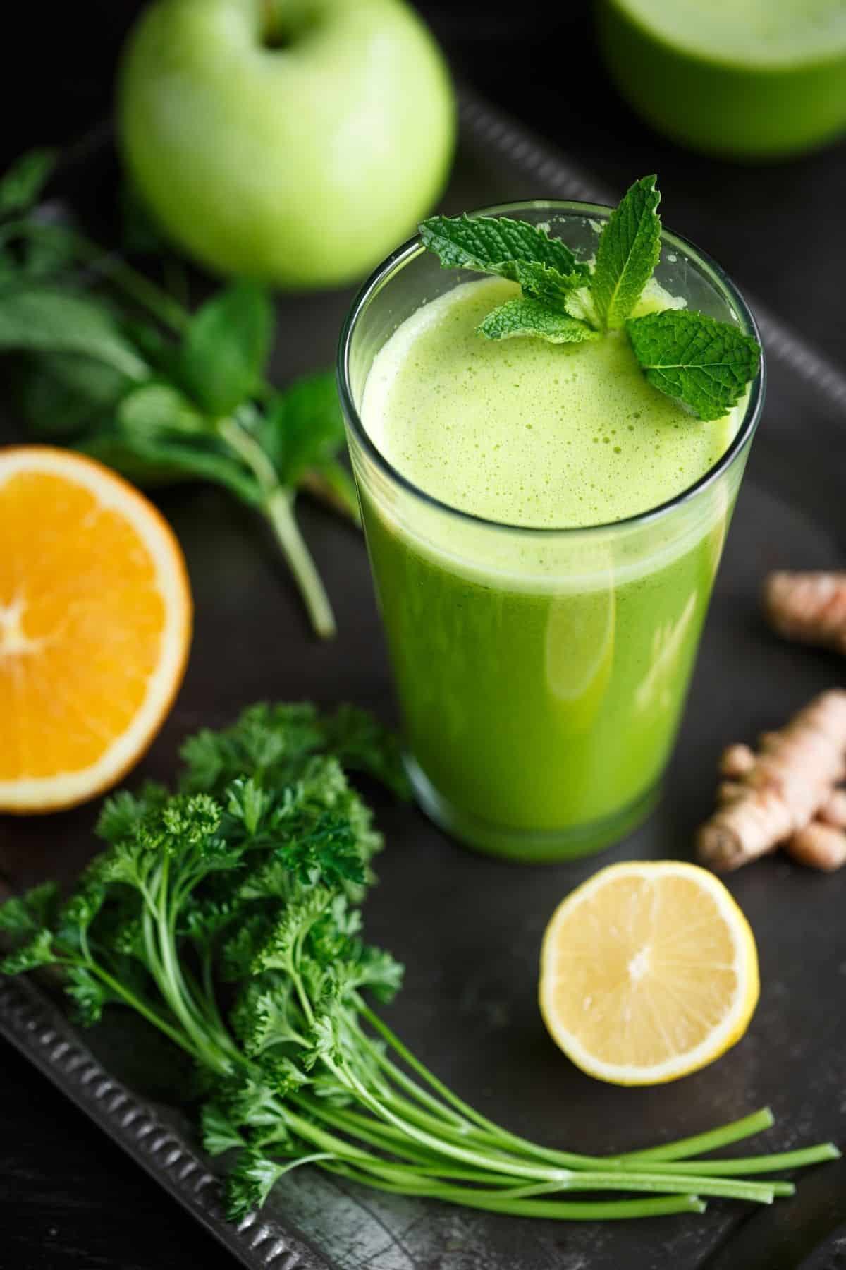 green juice served with mint, parsley, lemon, and apple