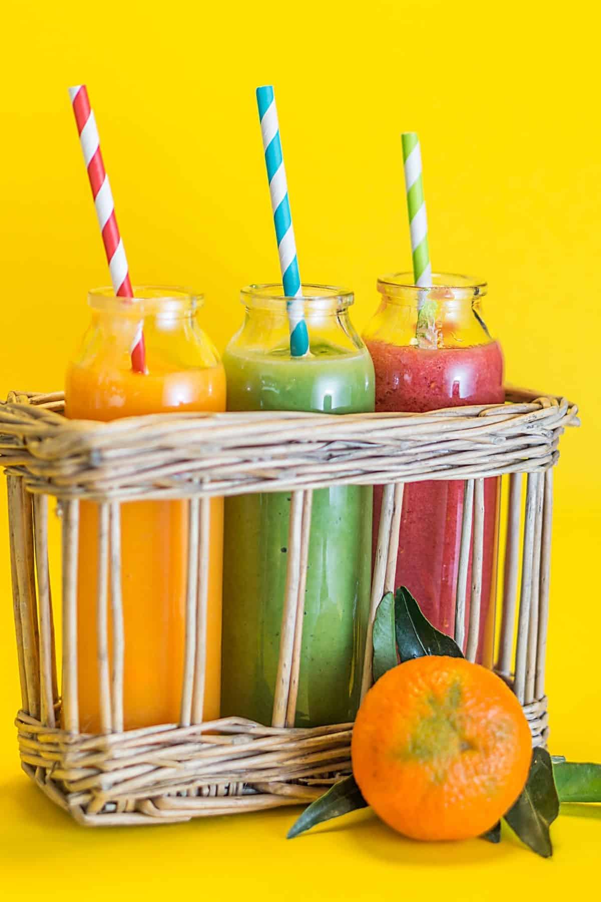 three dairy-free fruit smoothies with straws ready to drink.