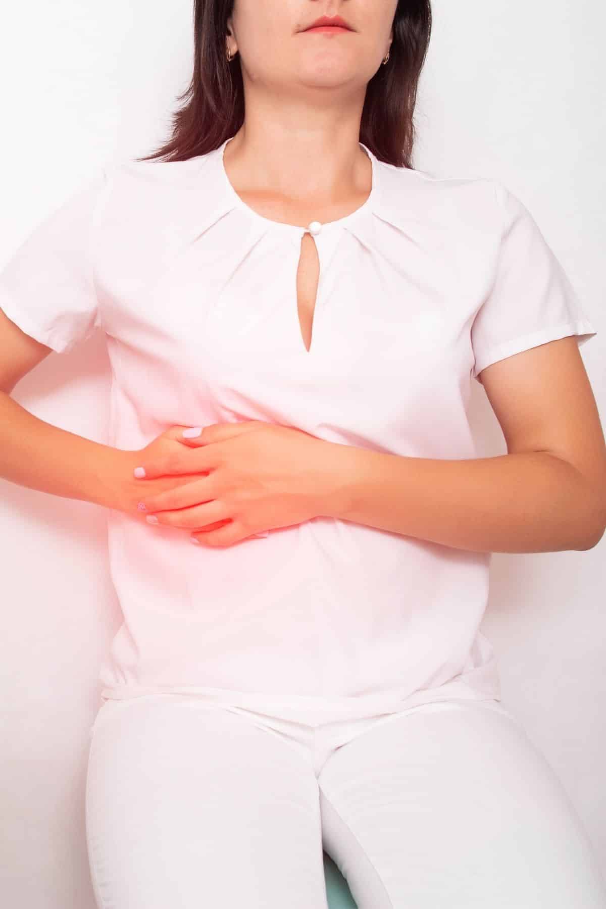 woman with gallbladder disease holding her abdomen.