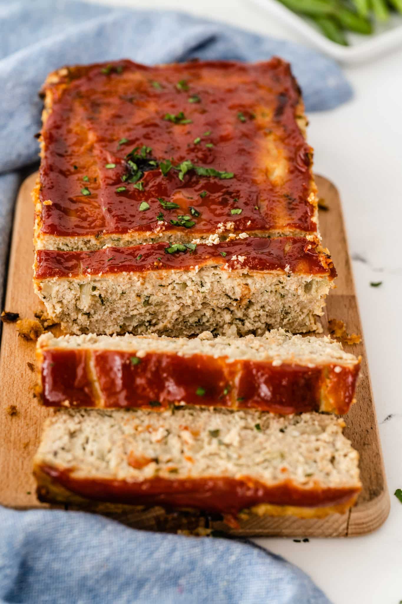 sliced chicken meatloaf with ketchup on top.