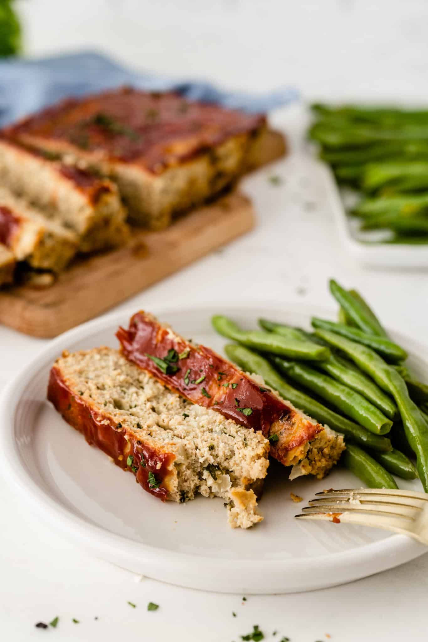 healthy chicken meatloaf served with roasted green beans.