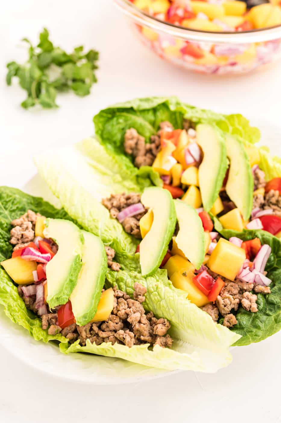 Ground chicken lettuce tacos with mango salsa and avocado