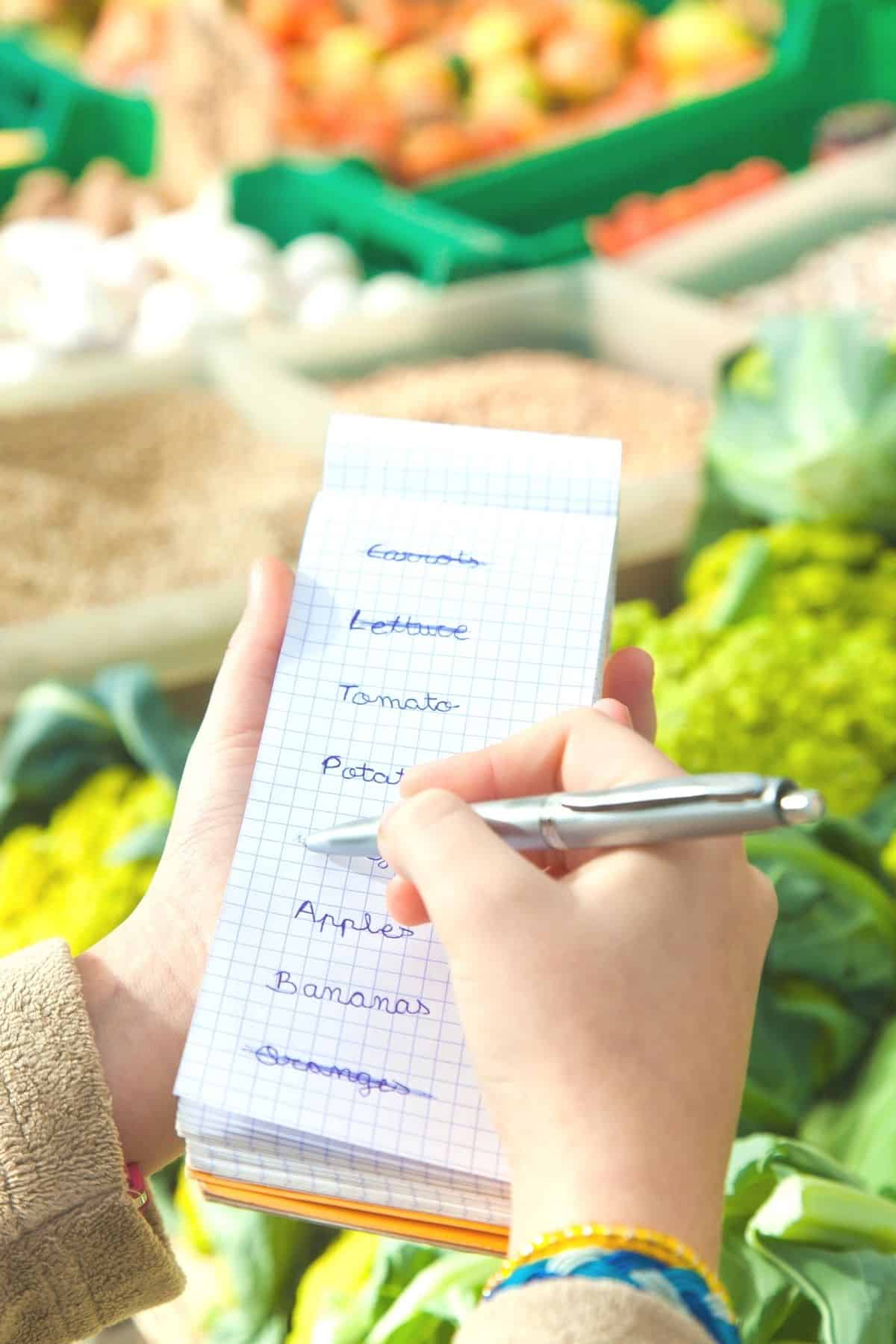 woman checking grocery items off a shopping list