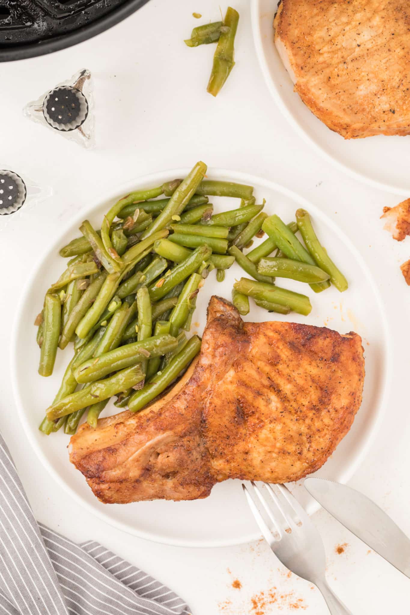 pork chops served on a plate with green beans.