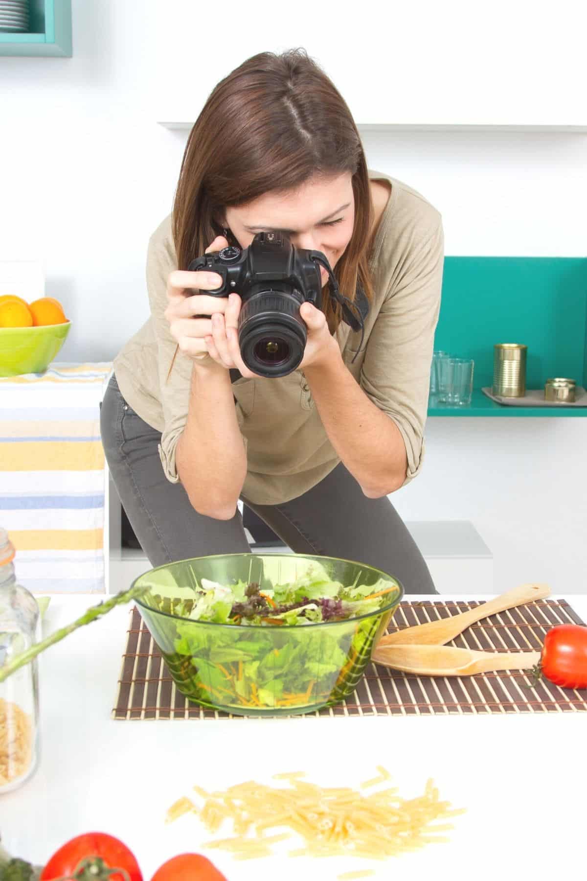 woman taking picture of a salad.