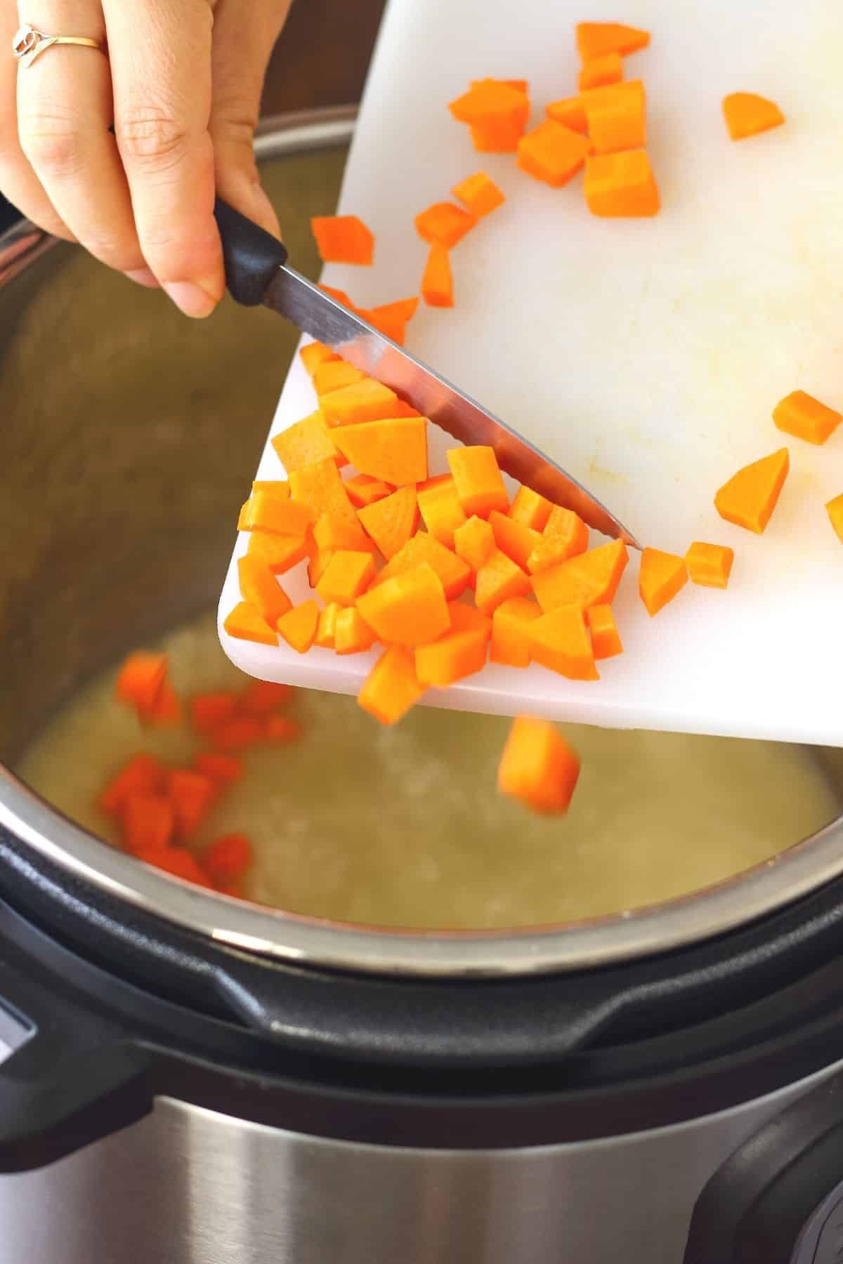 woman putting chopped carrots in an instant pot.