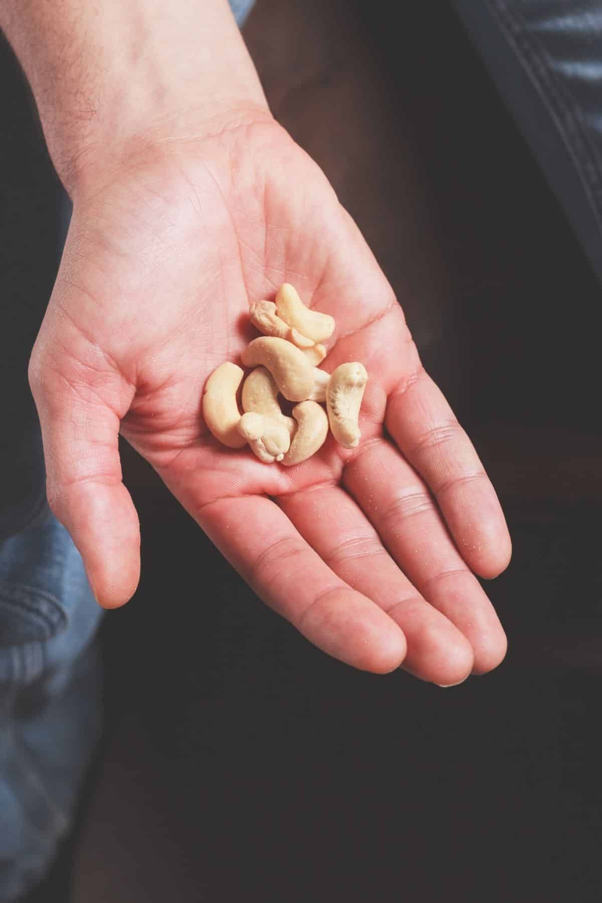 person holding a small handful of nuts