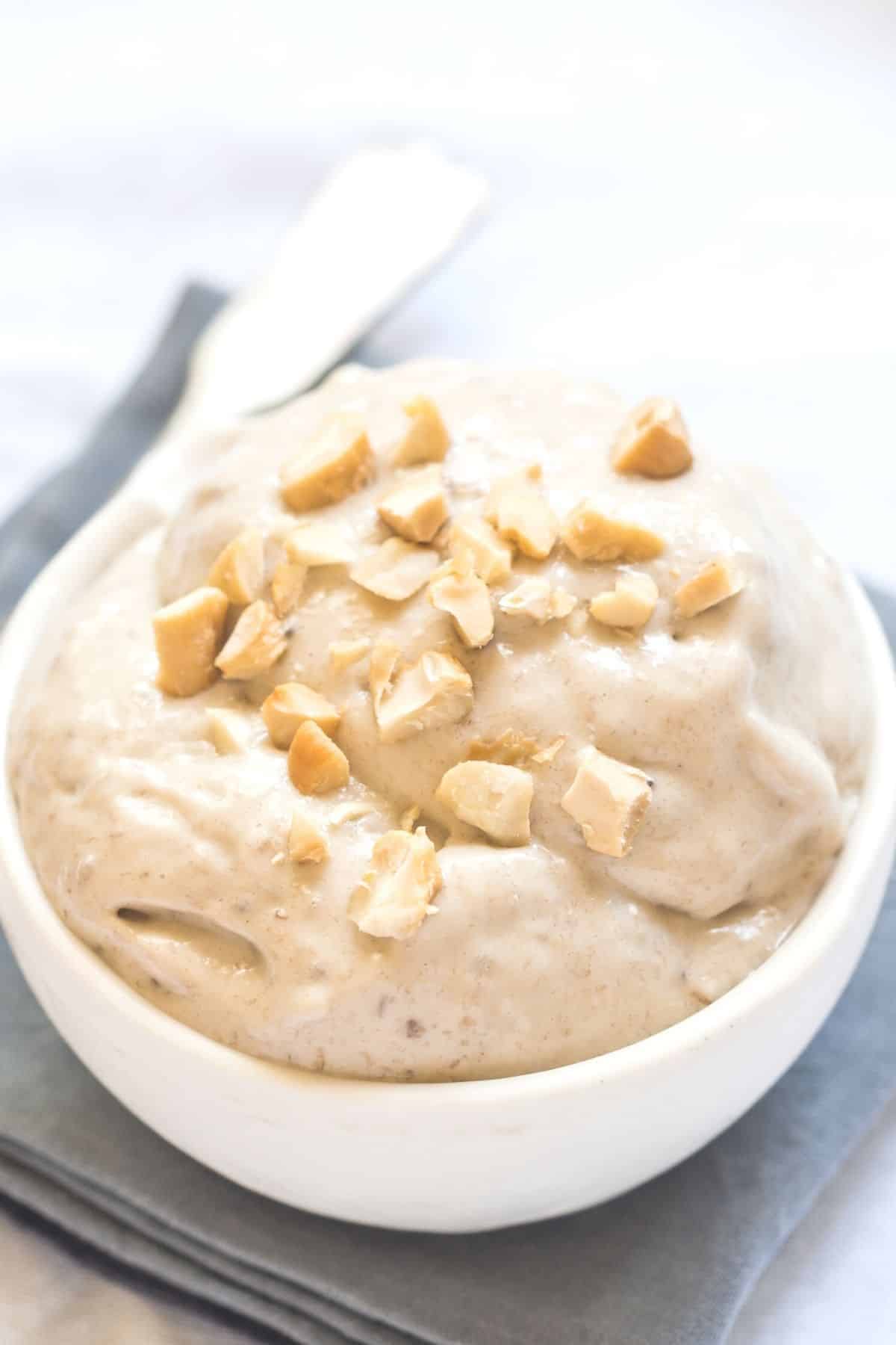 bowl of banana peanut butter nice cream in a white bowl with a spoon.