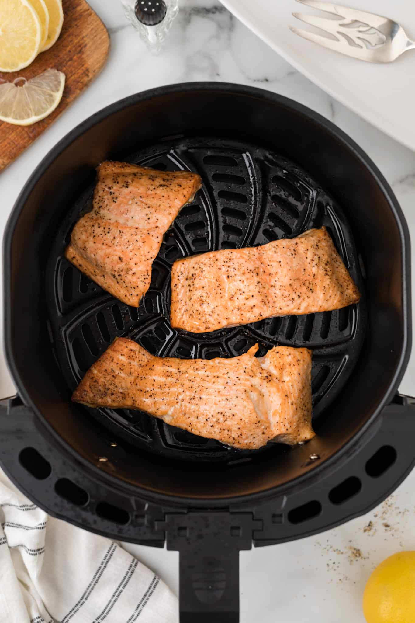 cooked salmon fillets in an air fryer.