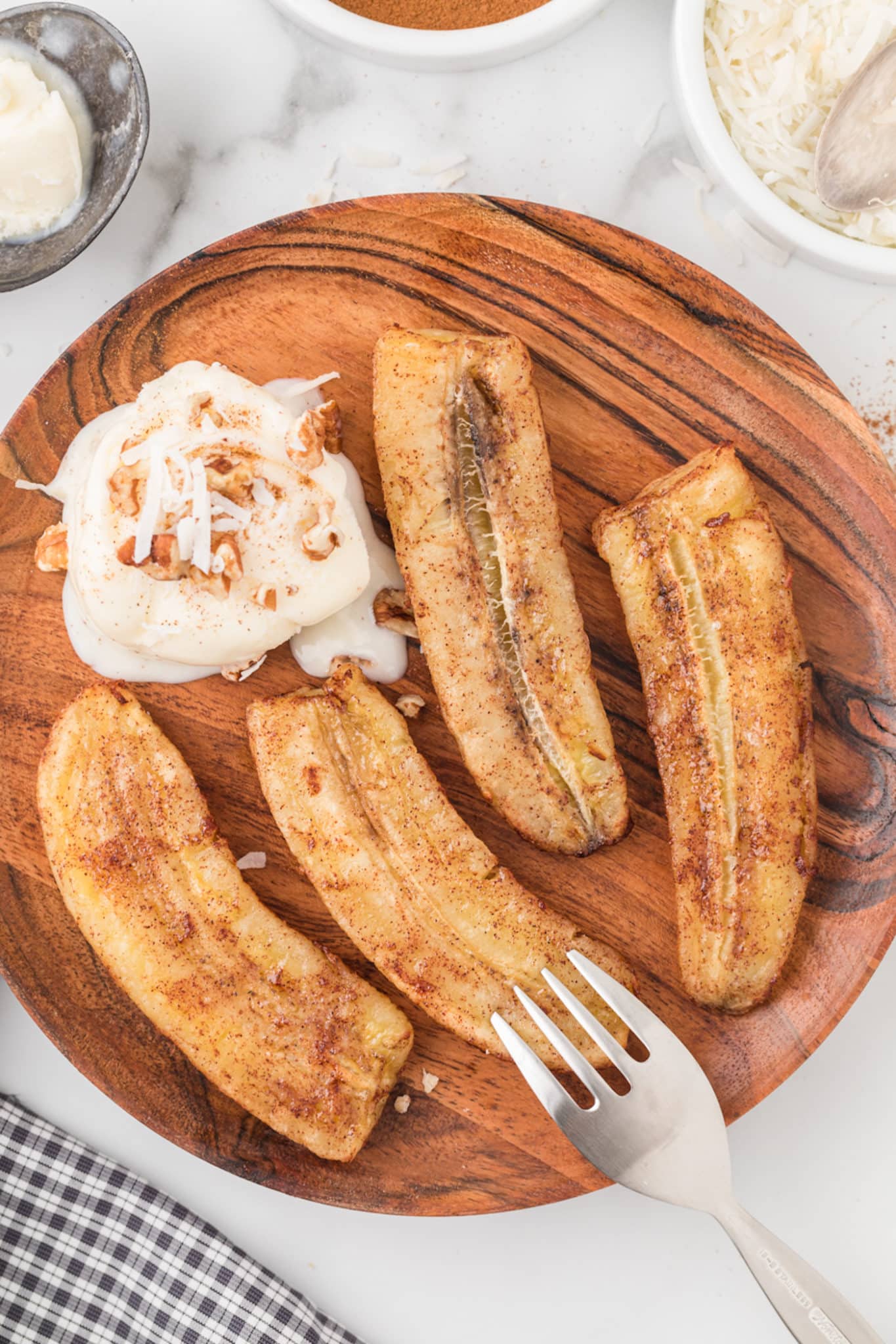 air fried bananas on a wooden plate with ice cream.