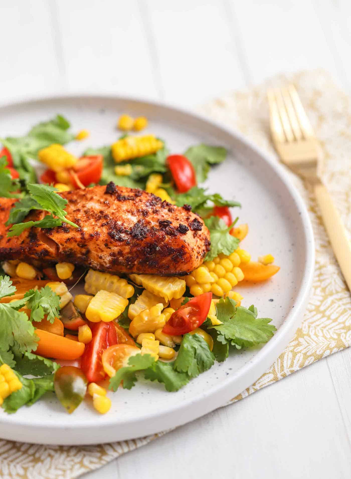 salmon served with salad and corn