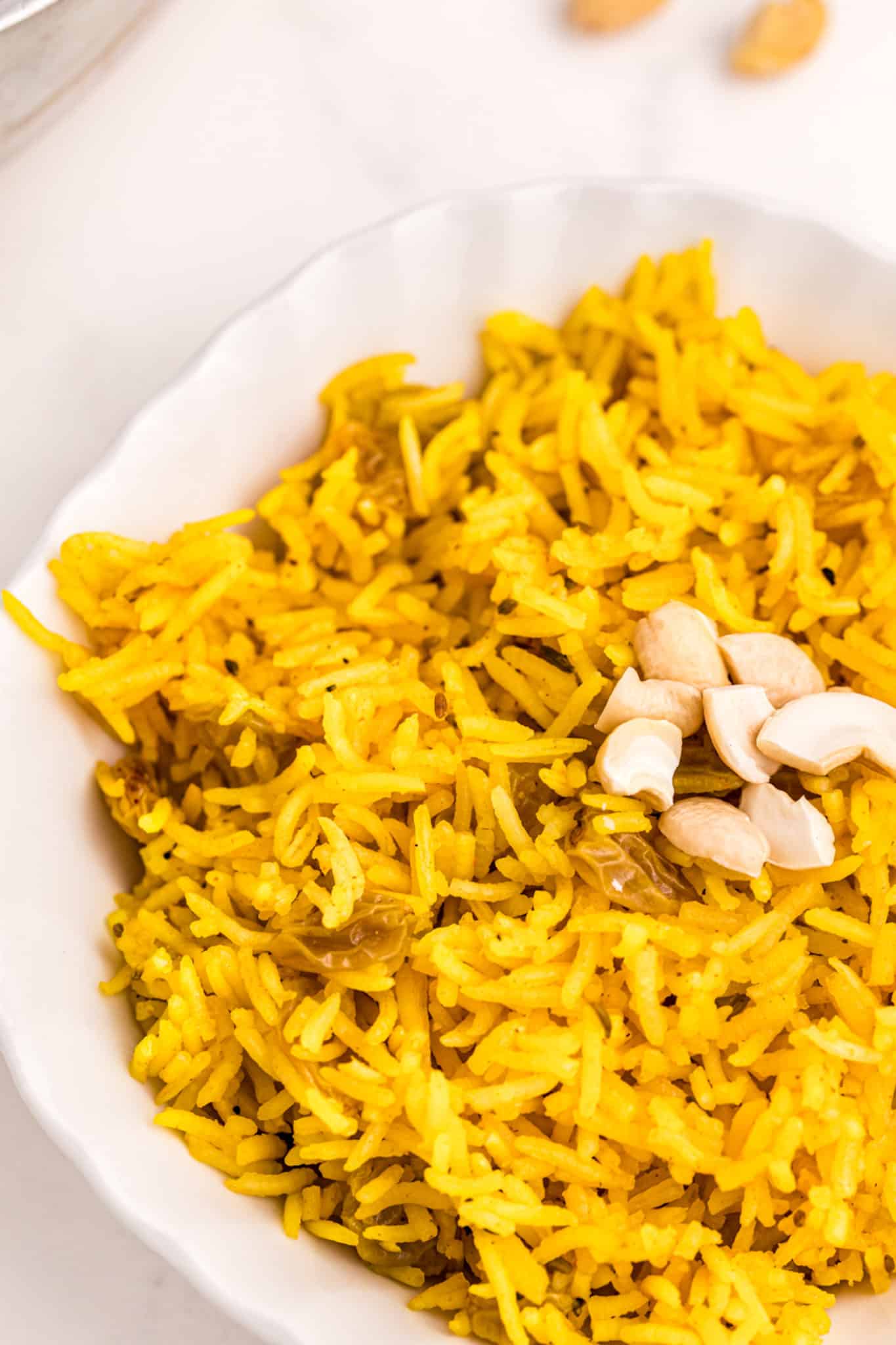 yellow rice served in a bowl with cashews on top