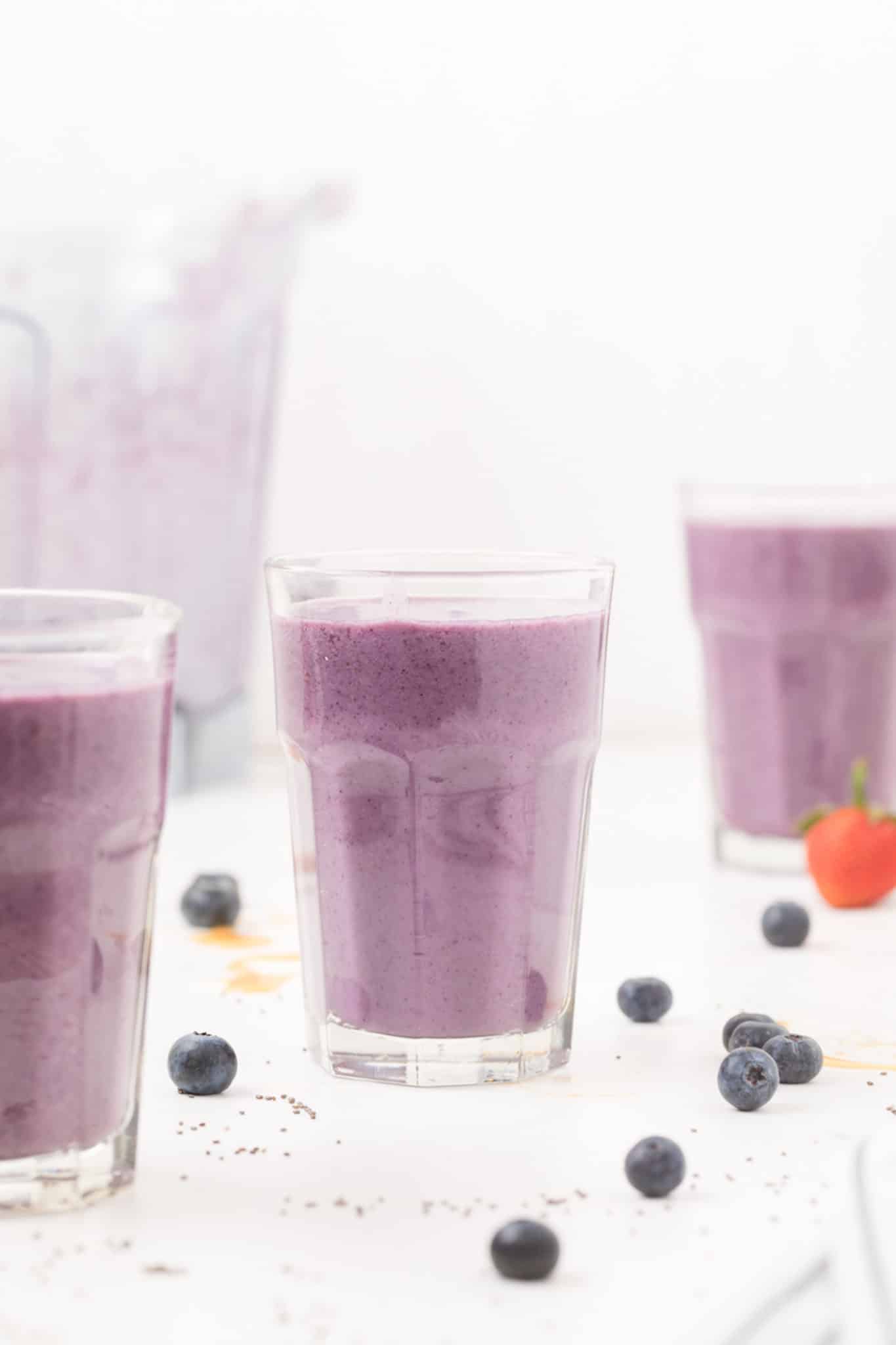 purple smoothie served in three glasses