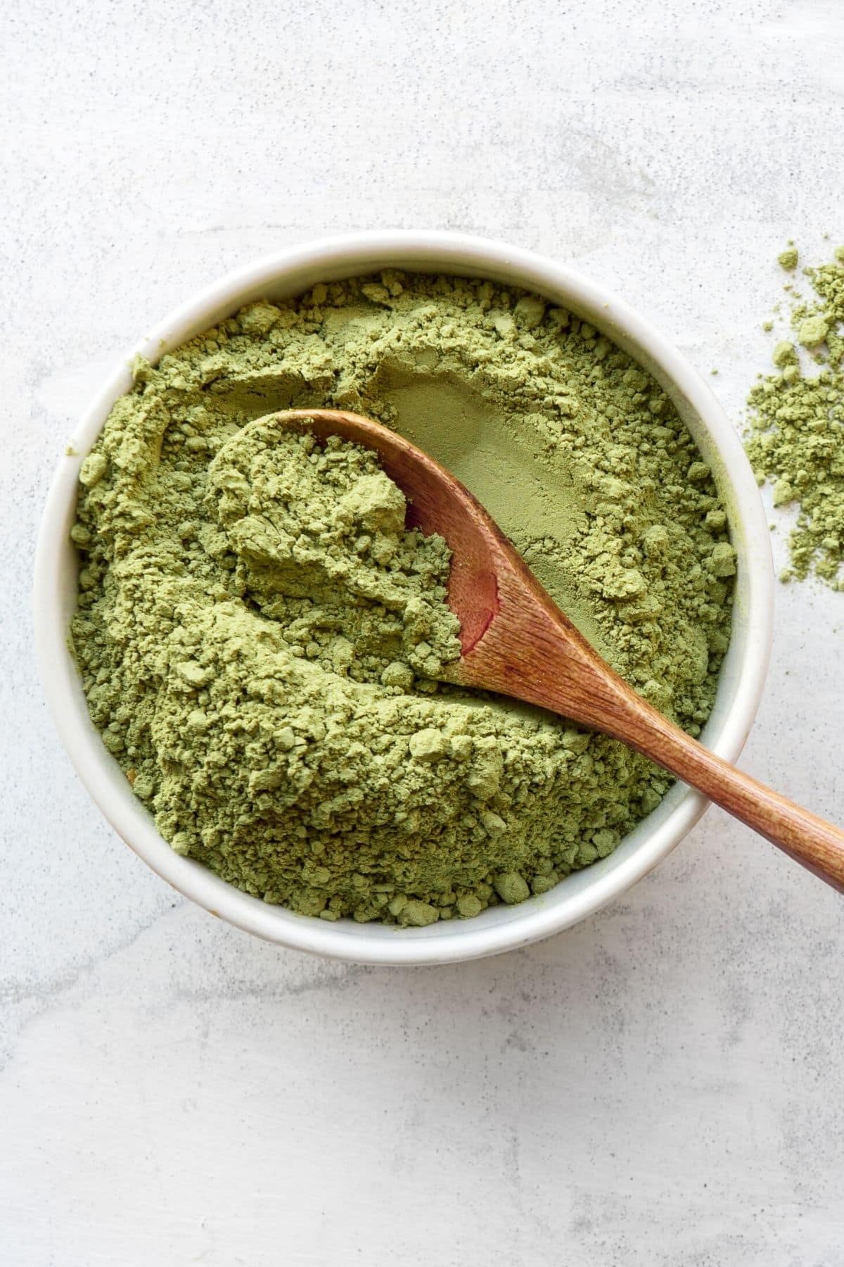 green broccoli sprout powder in a bowl.
