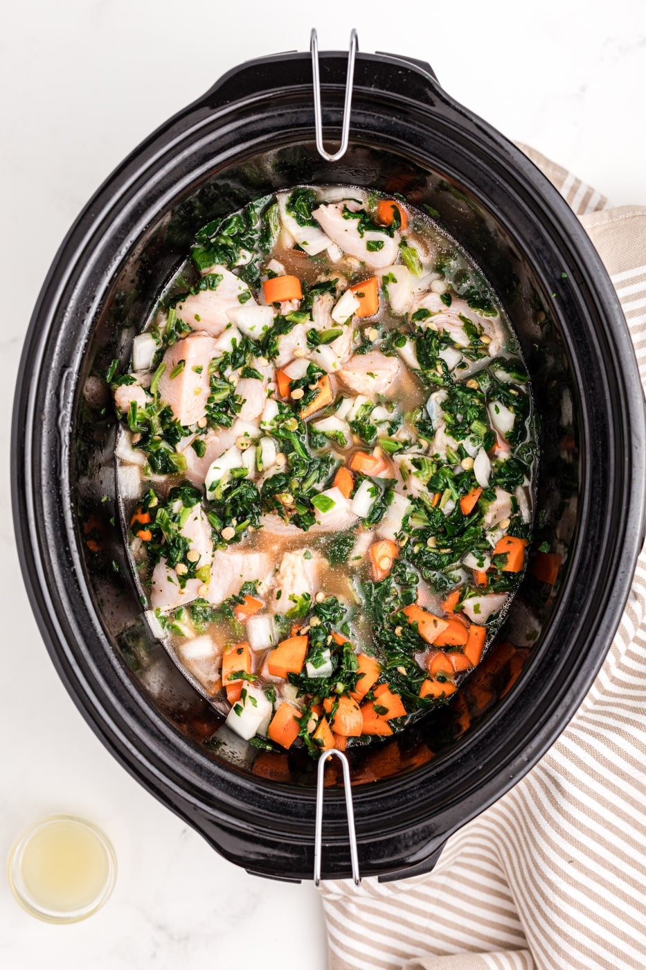a crockpot with chicken, lentils, and veggies