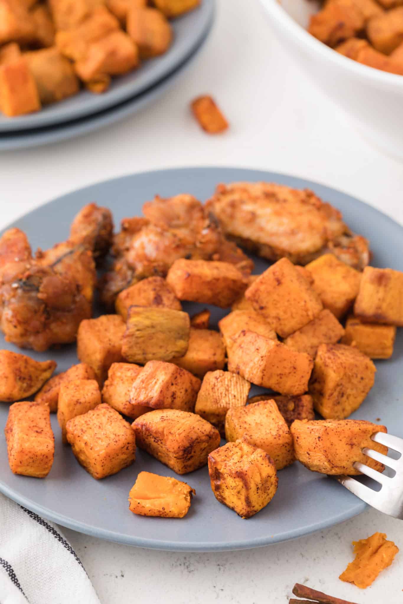 bowl of cooked sweet potato cubes on a blue plate.