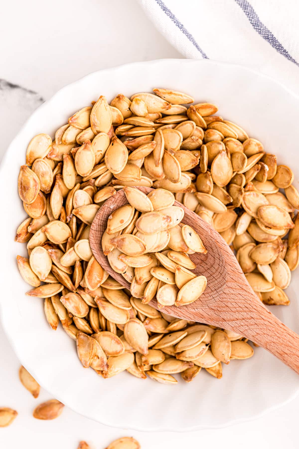 bowl of toasted pumpkin seeds with a spoon.