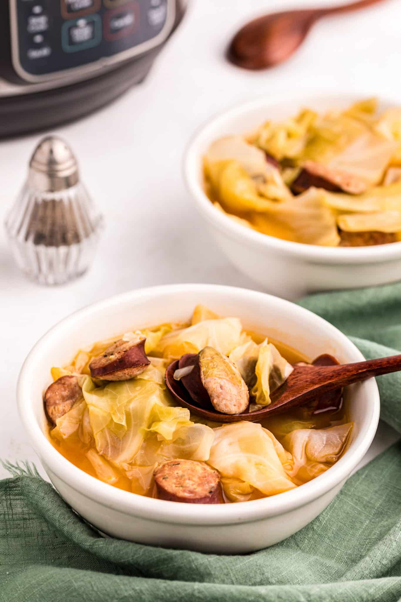 instant pot cabbage soup with sausage served in white bowl.