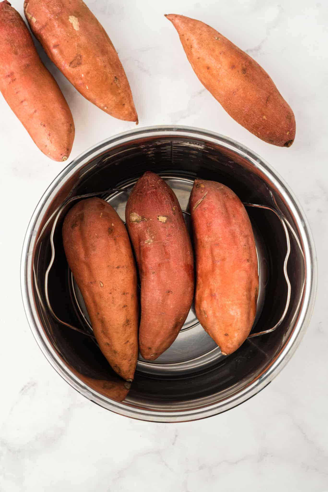 sweet potatoes on trivet inside instant pot.