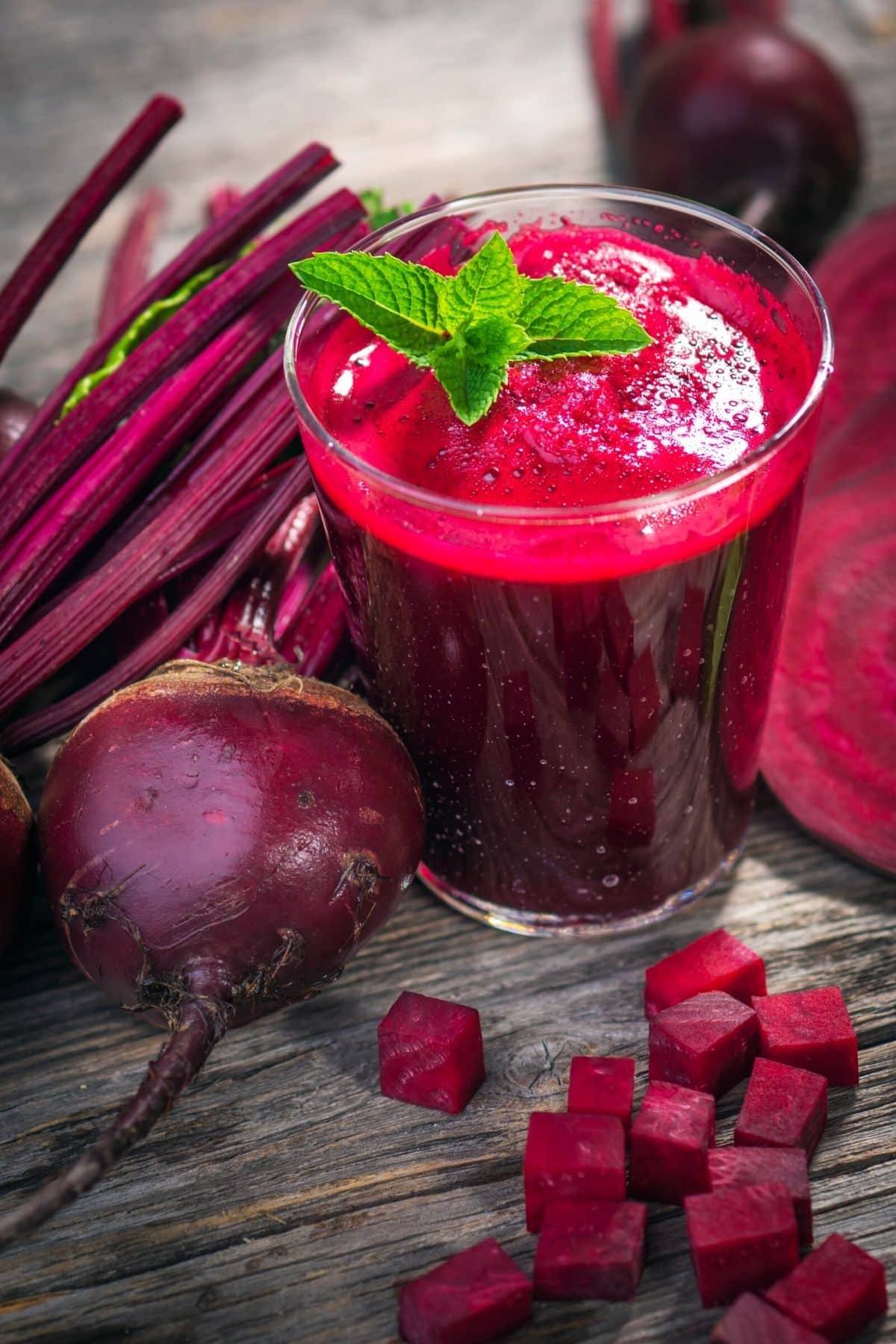 glass of beet juice on a table with fresh beets.