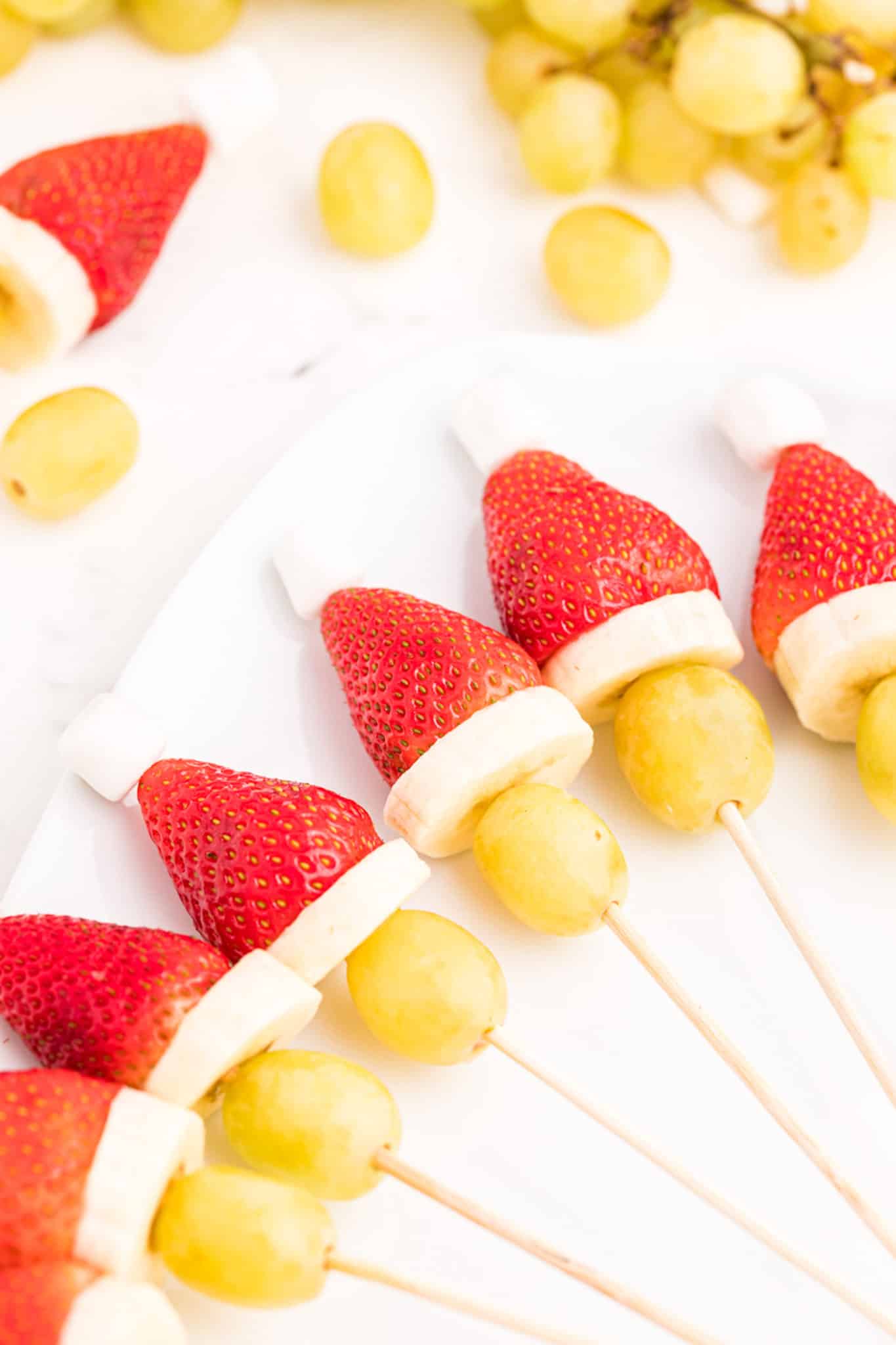 healthy fruit grinch kabobs on a plate.