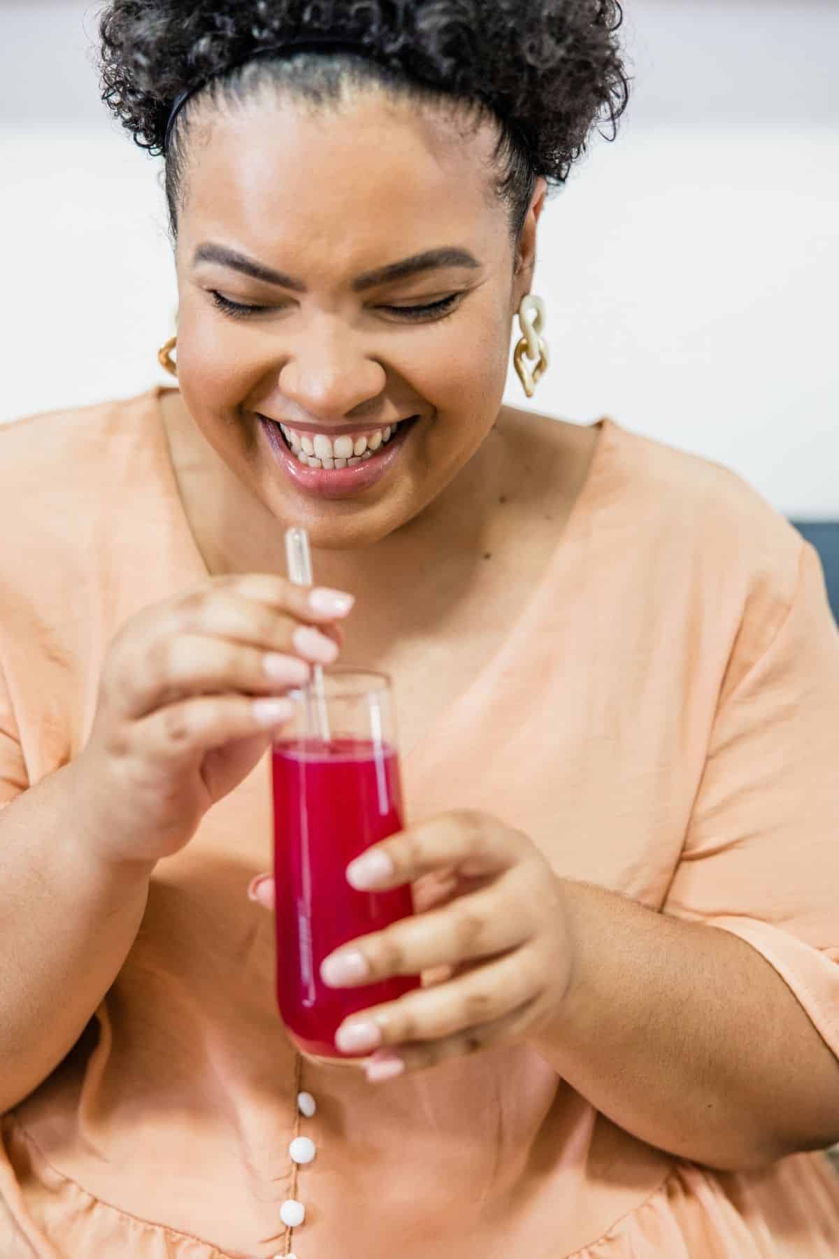 woman drinking a glass of beet juice.