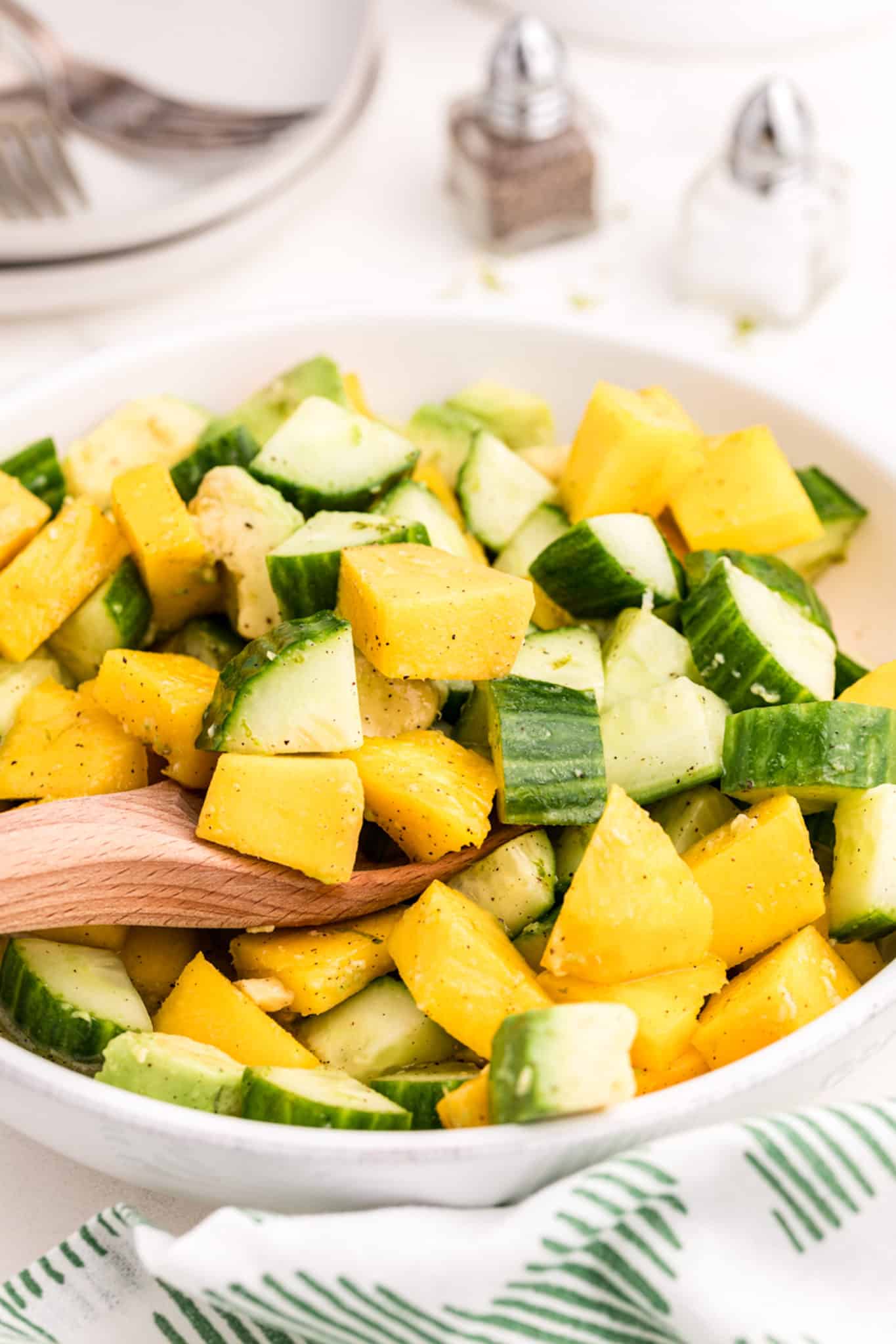 a bowl of mango and cucumbers.