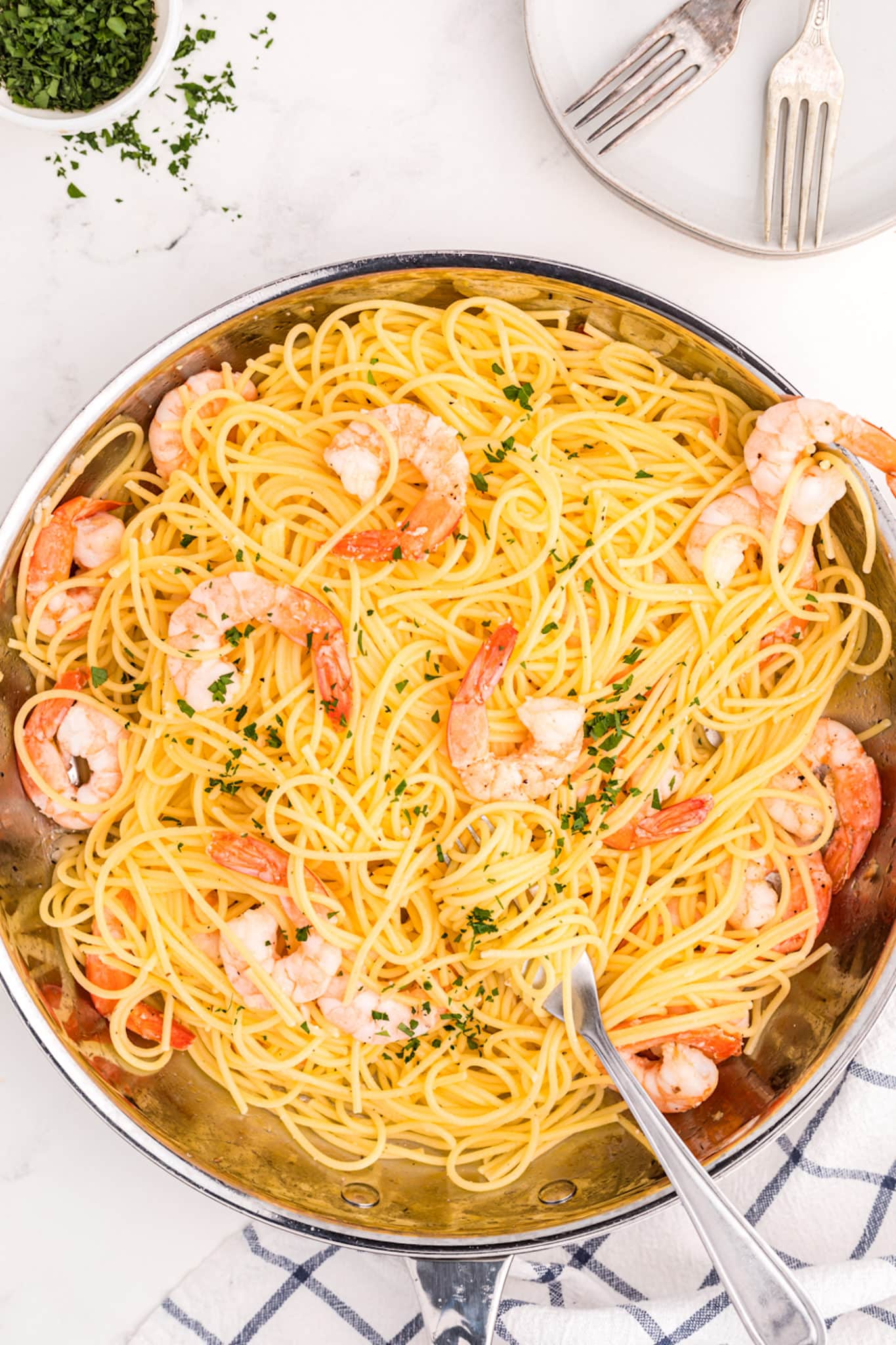a skillet with gluten free spaghetti and shrimp.
