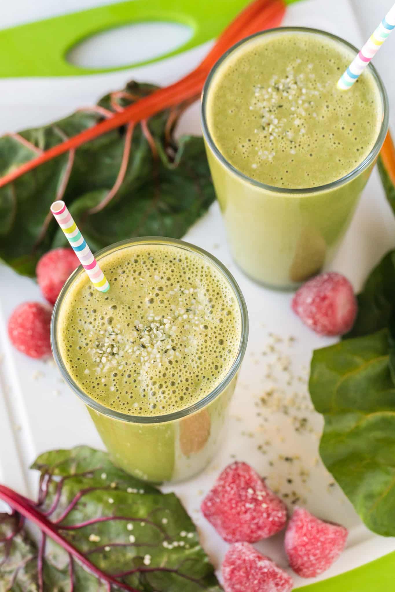 two glasses of swiss chard smoothie on a table.