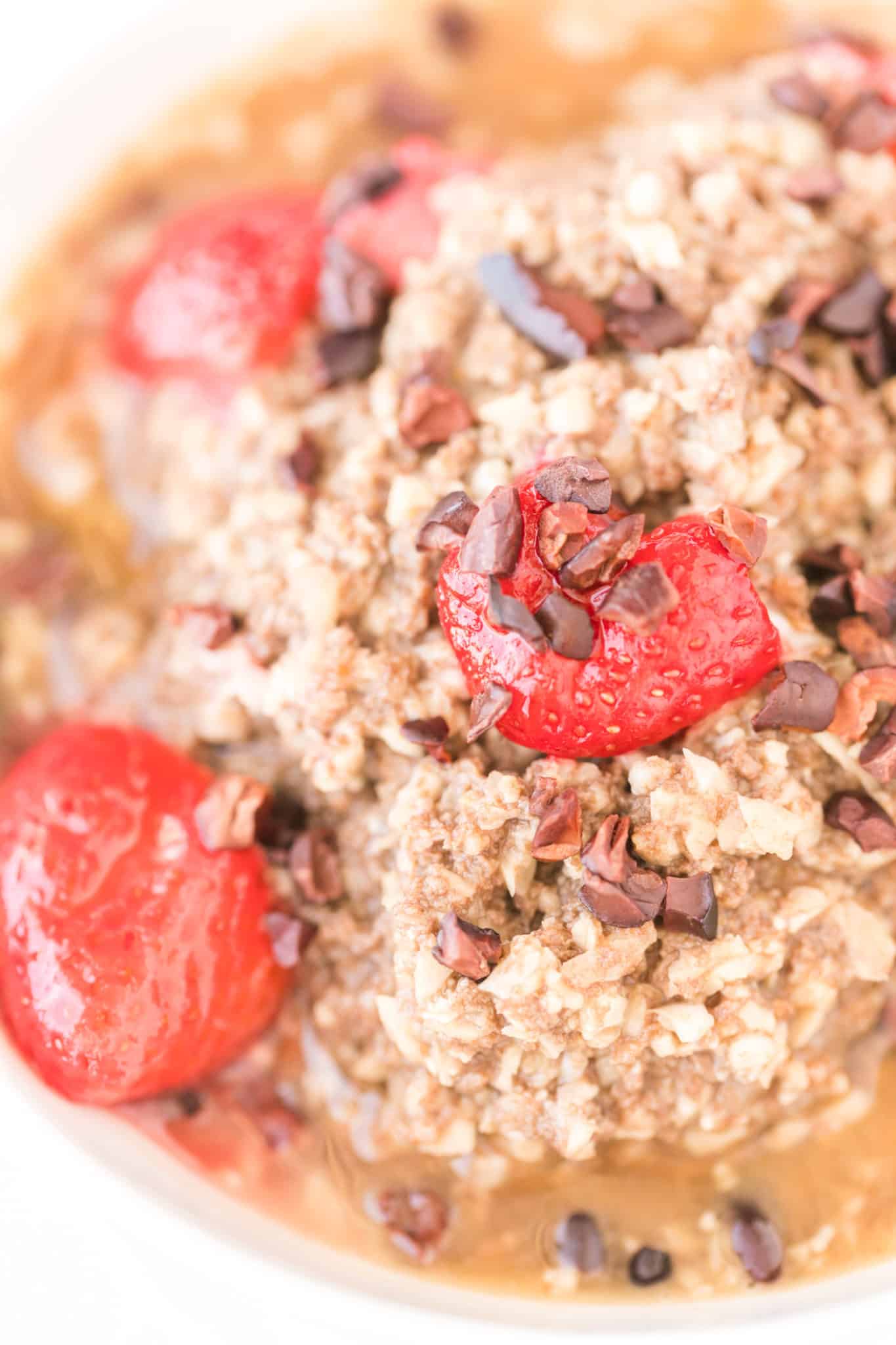 texture of cooked cauliflower oatmeal with strawberries and cacao nibs.
