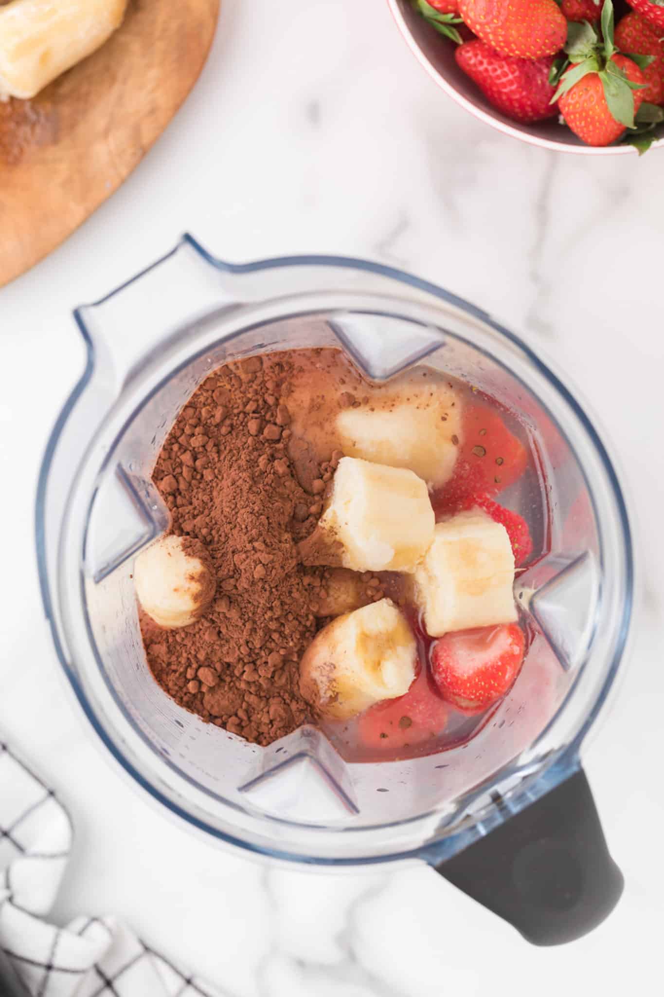 ingredients in blender for chocolate banana smoothie.