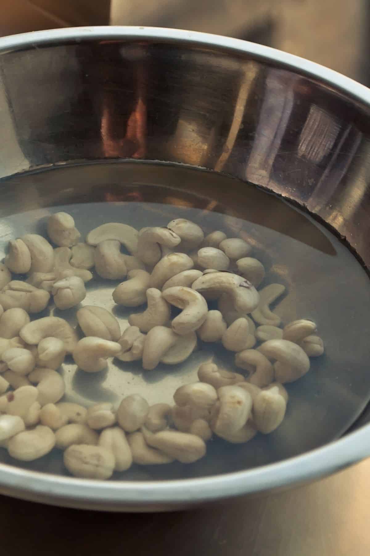 raw cashews soaking in bowl with water.