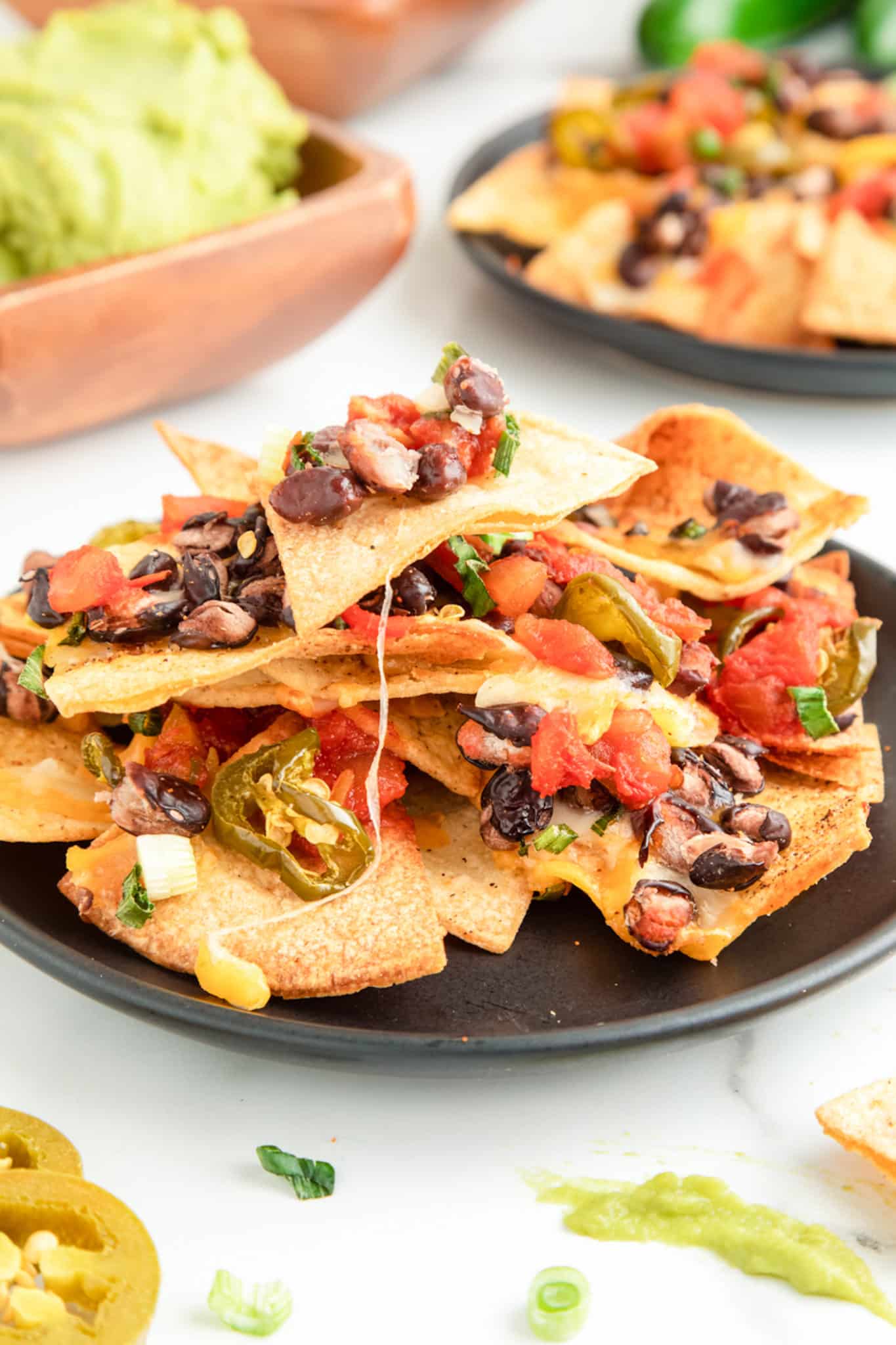 air fried nachos on a plate with melted cheese and black beans.