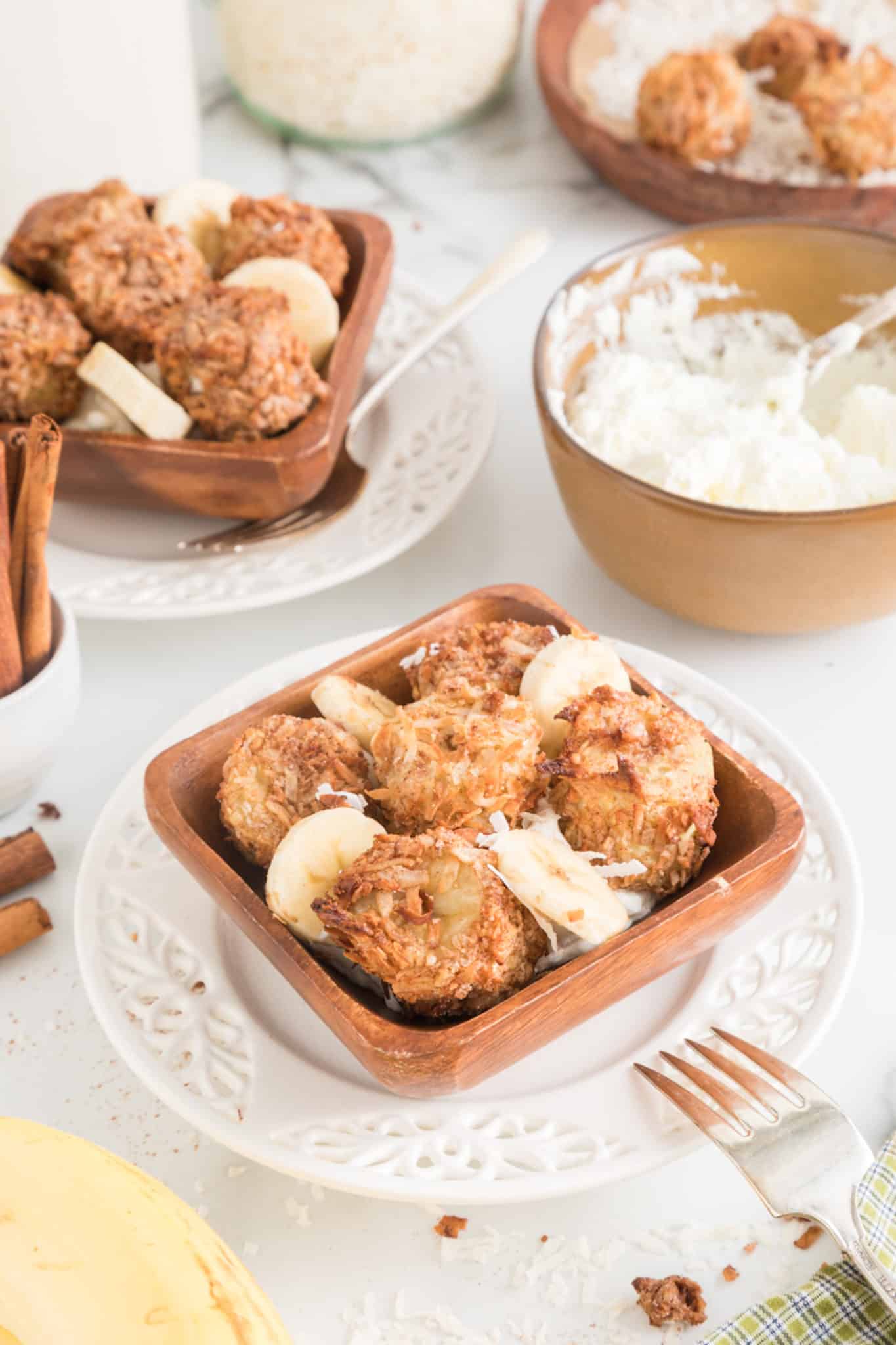 air fried banana fritters served in a bowl with fresh whipped cream.