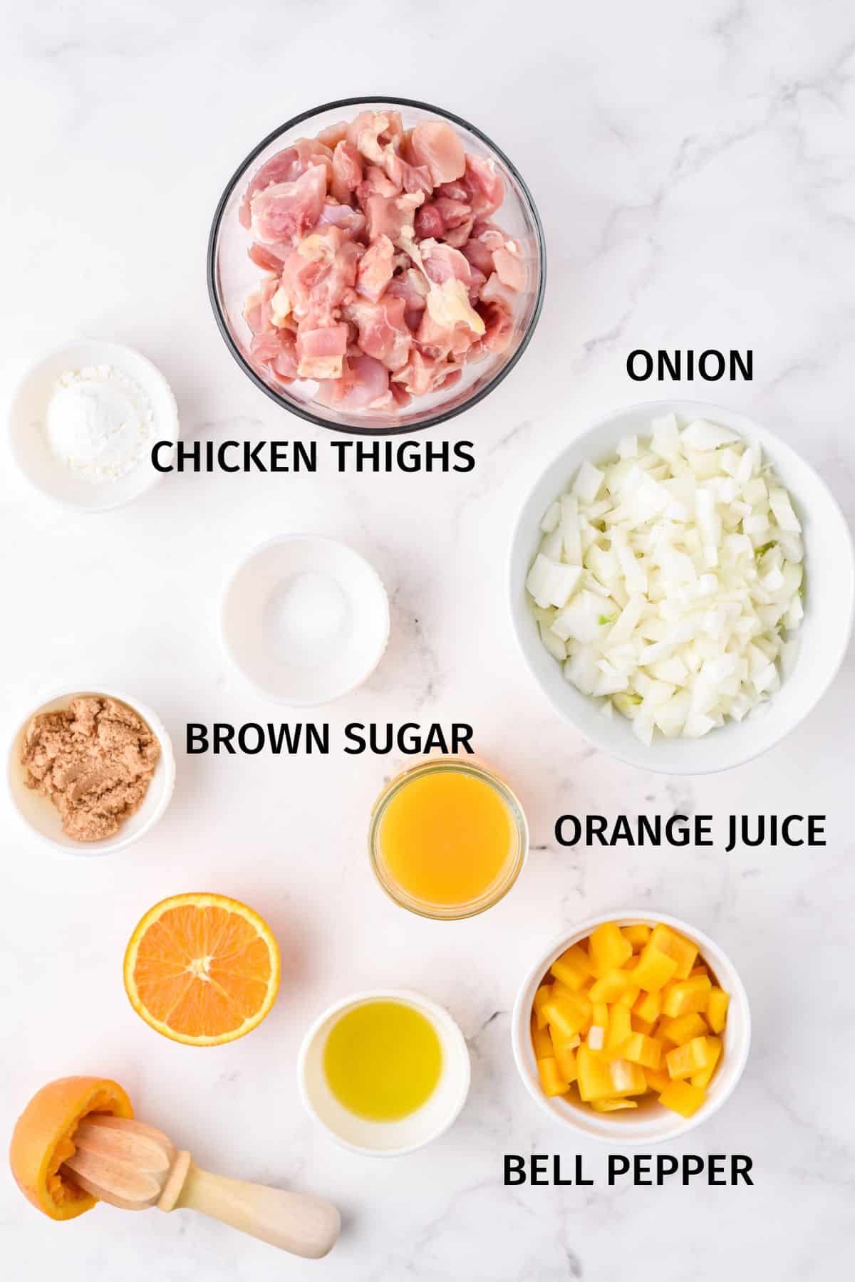 Ingredients for Instant Pot orange chicken in small bowls on a white surface.