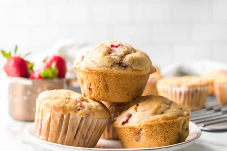 Strawberry muffins stacked up on a small white plate.