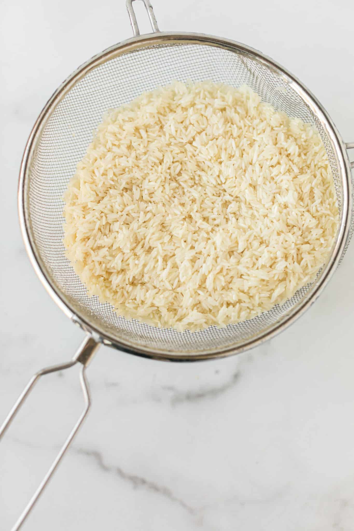 white rice in a strainer.
