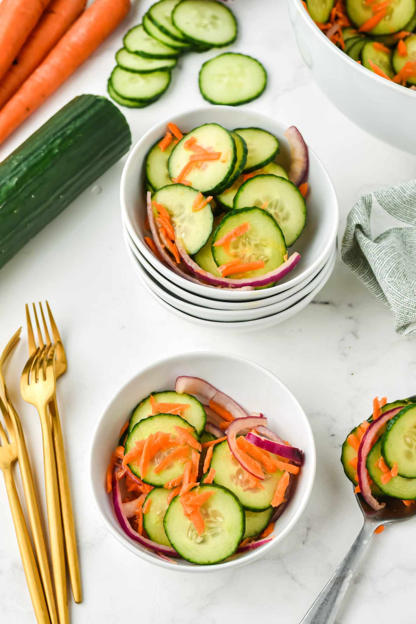 Small white bowls with servings of carrot cucumber salad.