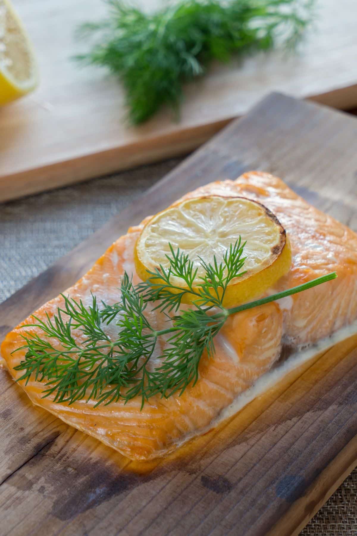 Cooked salmon fillet with lemon slice and fresh dill.