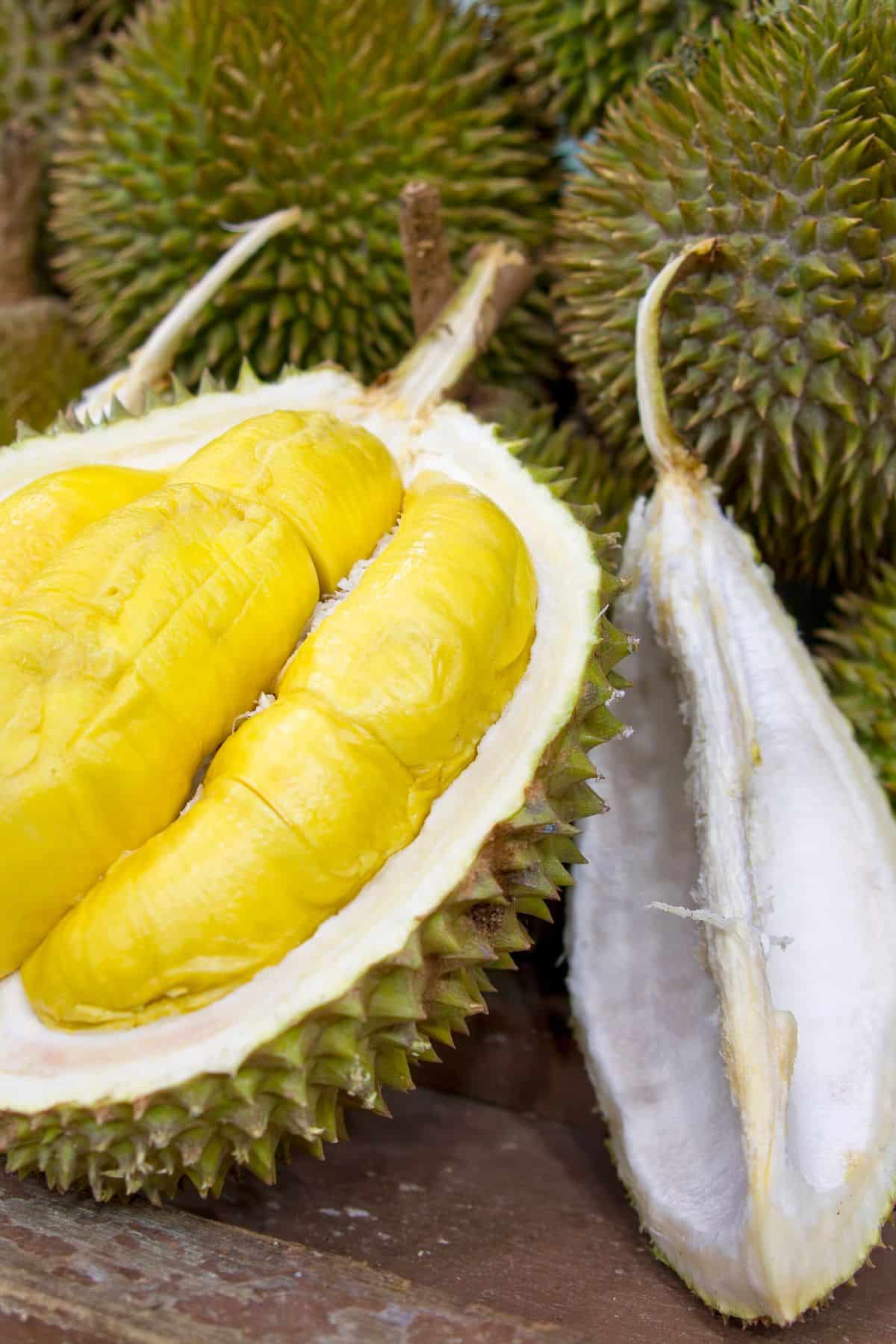 durian fruit on a table cut in half.