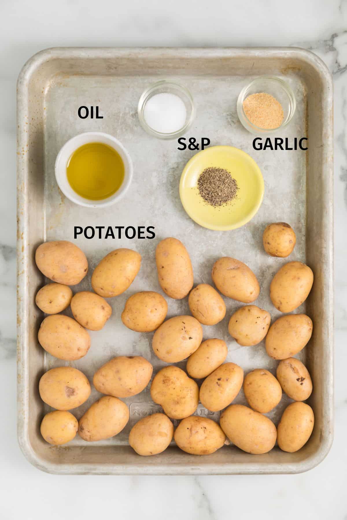 Ingredients to make air fryer smashed potatoes on a baking sheet.