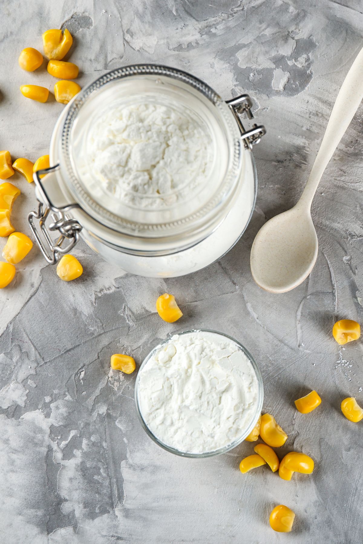 Jar of cornstarch with corn and spoon.